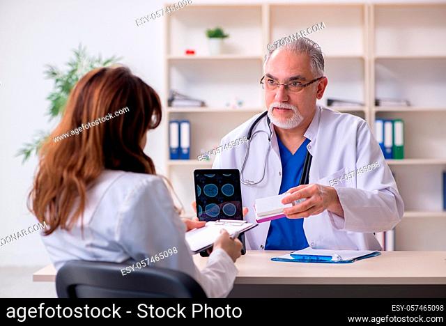 Old male doctor radiologist and his young female assistant in the clinic