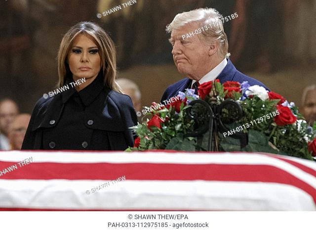US President Donald J. Trump and First Lady Melania Trump take a moment of silence at the casket containing the body of former US President George H.W