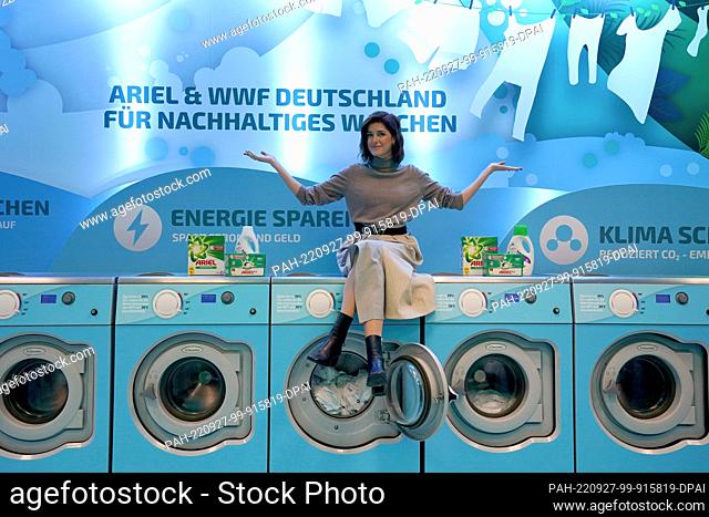 27 September 2022, Hamburg: Marie Nasemann, sustainability influencer, sits on the washing machines during the Cold Laundromat campaign in the Winterhude...
