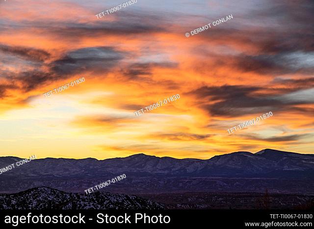 United States, New Mexico, High Road to Taos, Colorful sunset sky over Galisteo Basin Preserve landscape