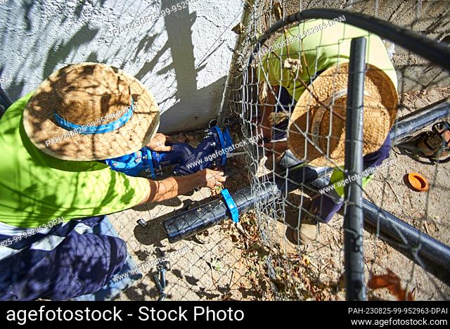 24 August 2023, Spain, La Pedriza: Two plumbers carry out repairs on the water pipeline in La Pedriza. Water disputes between different municipalities are...