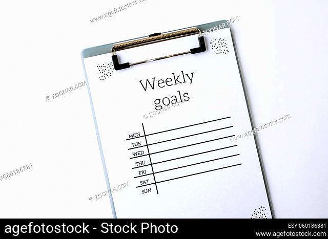 Weekly goals planner on white background. Planning week to stay productive when working from home during quarantine period. Flat lay. Top view