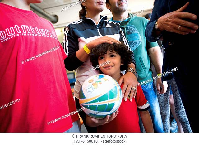 Little Abed al Rahman from Syria (bottom R) .queues with his family for a medical examination in a newly established refugee accommodation centre in a former...