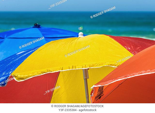 Colourful beach umbrellas provide protection (shade) from the harsh sun and the colours brighten the beach. Cape Town, South Africa