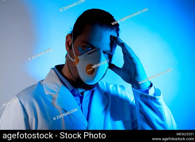 Medical doctor wearing a respiratory mask. Blue light emergency and medicine crisis concept