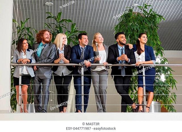 Young Business Man And Woman Group Stand Looking Up Happy Smiling Wearing Suits, Businesspeople Colleagues Team Modern Office Space