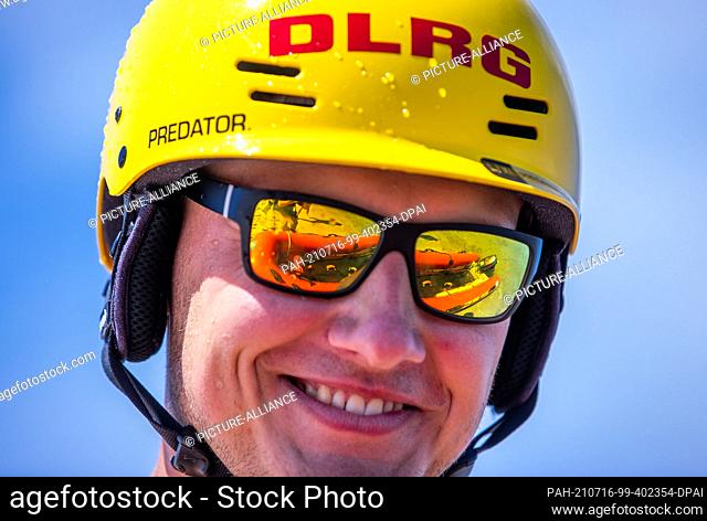 15 July 2021, Mecklenburg-Western Pomerania, Prerow: The lifeboat is reflected in the mirror goggles of lifeguard Nils Frechen from the DLRG water rescue...