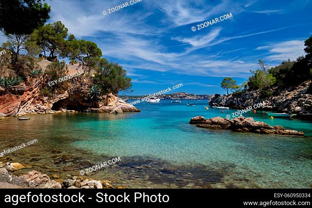 Moored luxury yacht and boars in picturesque beach Calo de ses Llises lovely cove of sand, stone and rocks in Peguera, Calvia, Mallorca Island, Baleares, Spain