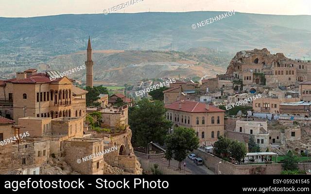 Urgup Town aerial view from Temenni Hill in Cappadocia Region of Turkey timelapse. Old houses and buildings in rocks at early morning with cars on a road