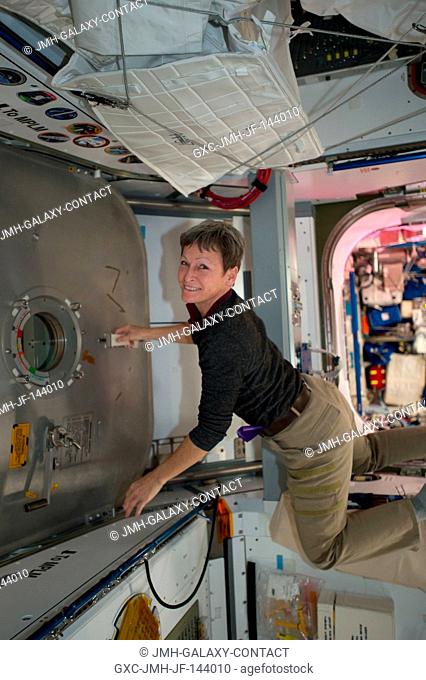 Expedition 50 crew member Peggy Whitson of NASA works inside the Harmony module to open the hatchway to the Japanese HTV-6 cargo craft