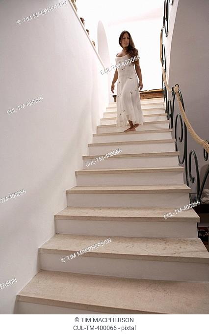 Mature woman descending staircase, low angle view