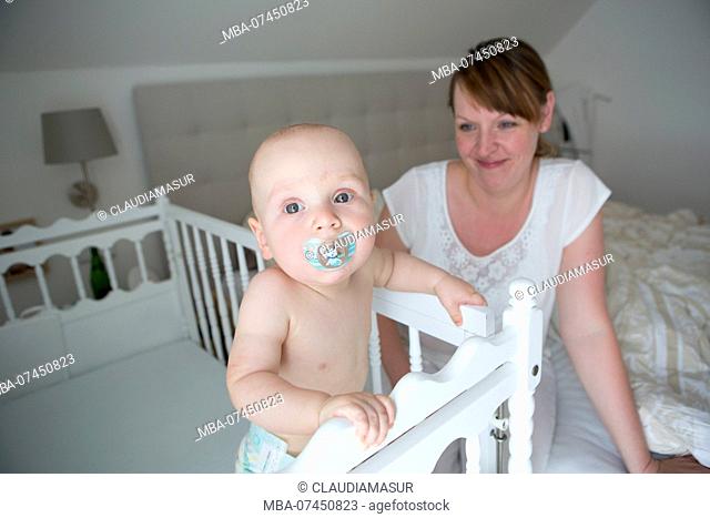 Mother with baby on cot