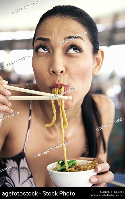 Filipino woman eating noodles