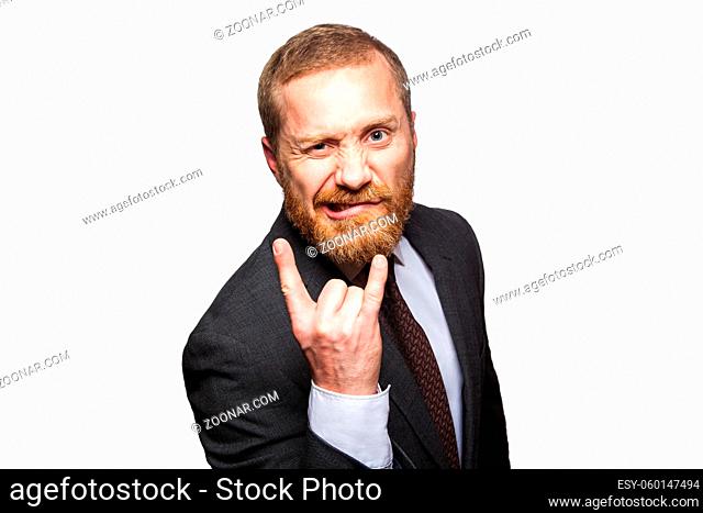 Funny businessman making horn gesture - rock and roll sign. isolated on white background, looking at camera