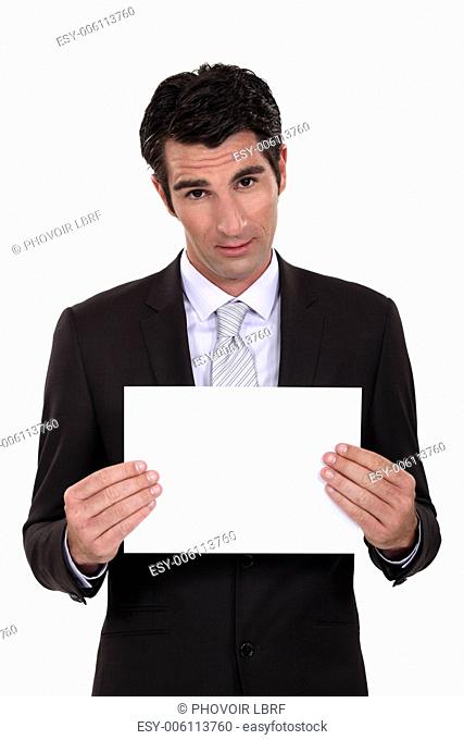Man in suit showing blank sheet of paper