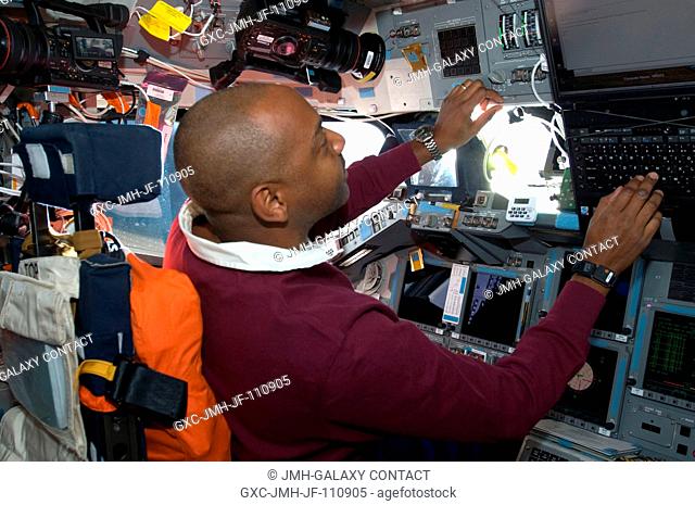 Astronaut Robert L. Satcher Jr., STS-129 mission specialist, occupies the commander's station on the flight deck of Space Shuttle Atlantis during flight day two...