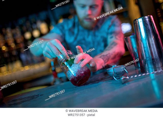 Bartender preparing cocktail at counter