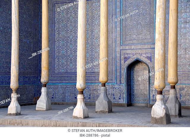 Wooden columns at wall decorated with fine blue maiolica Ko'xna Ark Itchan Kala Khiva Uzbekistan