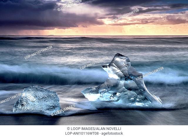 Icebergs washed up on the shore of Jokulsa volcanic beach at sunrise