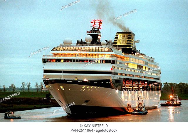 The 249 m long and 32 m wide cruise ship ""Century"" is, held by a tug, in the dusk before Leer. The 70, 000-tonne luxury liner completed by Meyer-Werft...