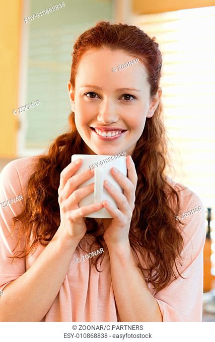 Smiling woman with her cup of coffee