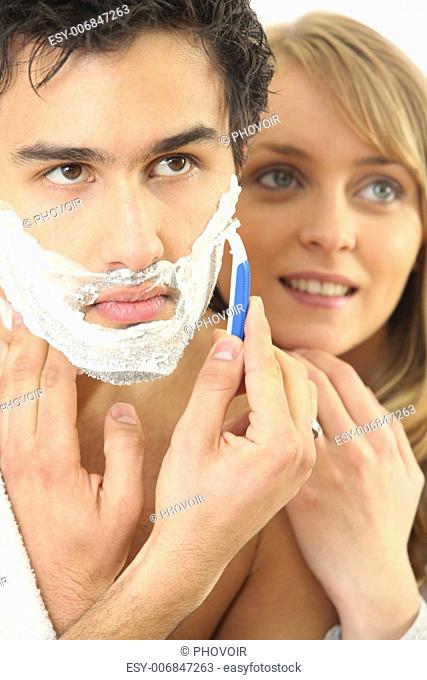 Young woman embracing her boyfriend while shaving