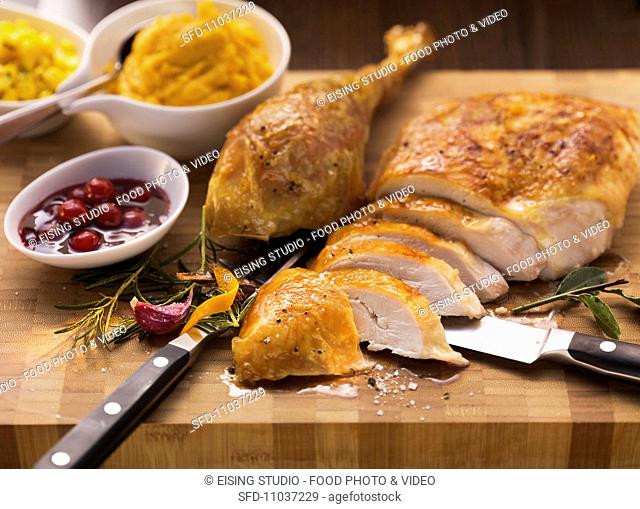 Sliced roast turkey with cranberry sauce and sweet potato puree