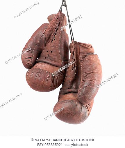pair of very old vintage brown leather boxing gloves hanging on a black rope, object isolated