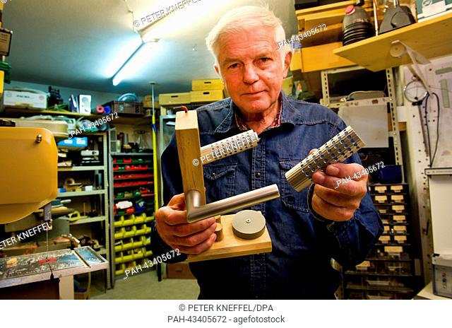 Inventor Bruno Gruber holds his antibacterial door handle in Olching, Germany, 15 October 2013. For 35 years, 72 year old Gruber has been inventing new products