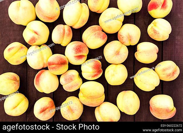 Flat lay with many large and big juicy organic peaches group on brown wooden table background with old boards. Natural fruits, copy space area
