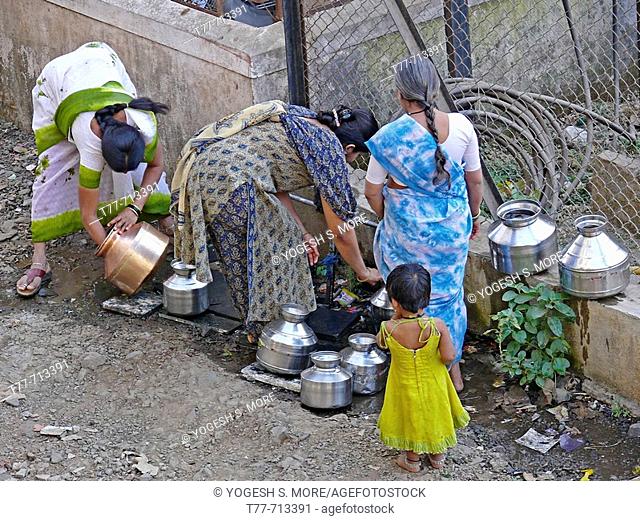Women are filling water in steel vessels  Pune, Maharashtra, India