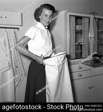 The housewives' association shows a strapless apron on its ""dowry show"" on 21 June 1955, which can be put on in a matter of seconds and can be fastened with a...