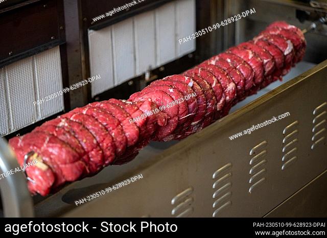 PRODUCTION - 08 May 2023, Rhineland-Palatinate, Trier: A roast beef spit roast is skewered in the grill. The Spit Roast Club Trier is the oldest spit roast club...