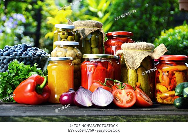 Jars of pickled vegetables in the garden. Marinated food