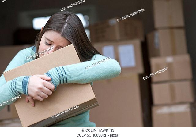 Teenage girl hugging cardboard box