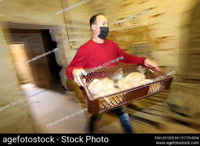 29 October 2020, Saxony-Anhalt, Halberstadt: Baker Mathias Hlady from the Halberstadt Bakers and Confectioners carries a box of fresh stollen into the...