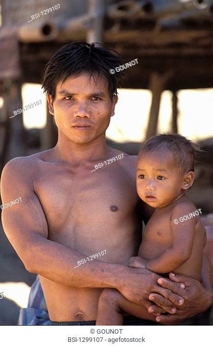 A father and his son. The picture was taken in a village of the tribe Khamou located at the north-west of Laos, near the small town Pakbeng on the border of the...