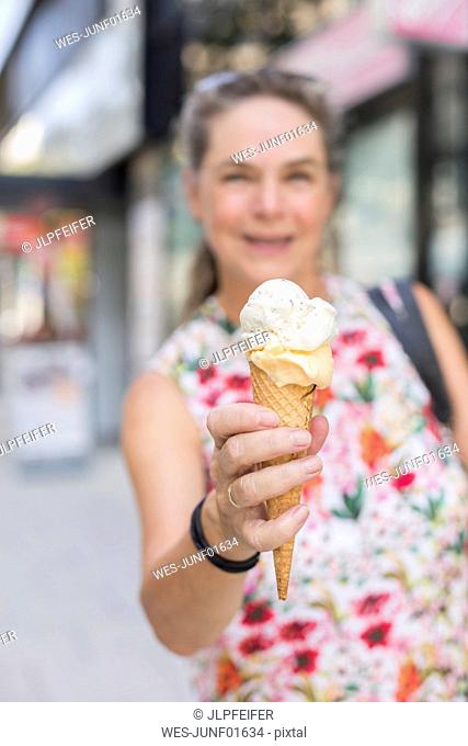Woman's hand holding ice cream cone, close-up