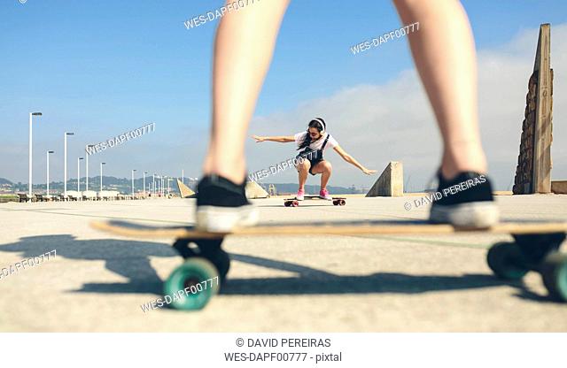 Young woman longboarding on beach promenade