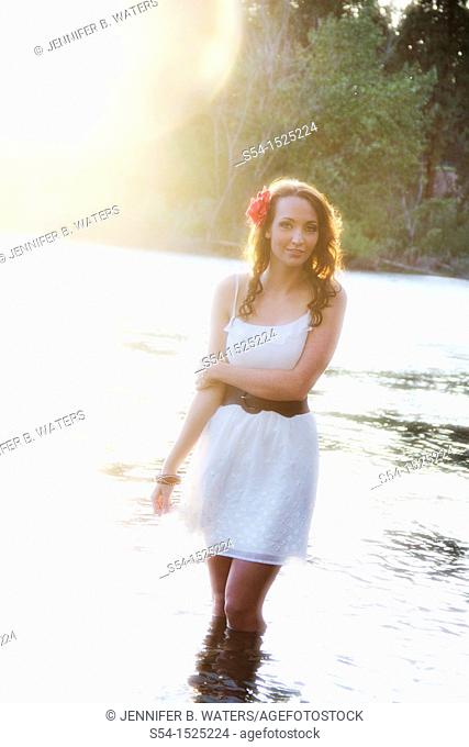 A beautiful young caucasian woman outdoors in Spokane, Washington, USA, standing in the Spokane River
