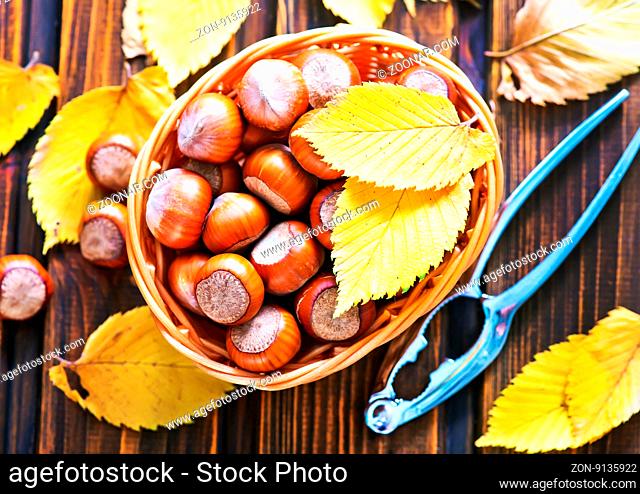 autumn leaves and hazelnuts on a table