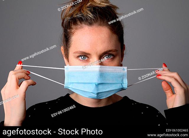 Young woman wearing surgical blue mask for corona virus. Pandemic. High quality photo
