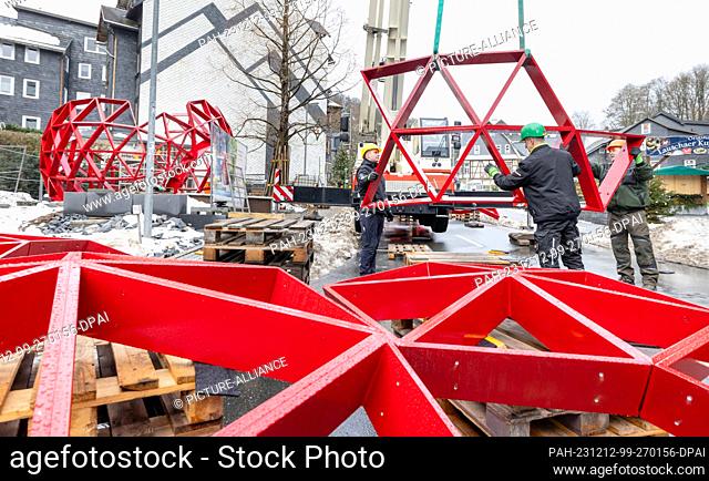 12 December 2023, Thuringia, Lauscha: Steelworkers assemble metal elements into a walk-in Christmas tree ball with the help of a crane