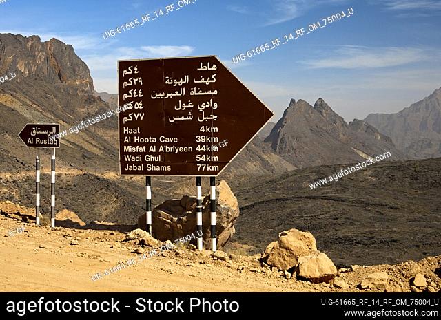 Directional sign at a crossroads of rough roads between Al Rustaq and the the Al Hoota Cave in wild mountainous landscape, Al Batinah Region, Sultanate of Oman