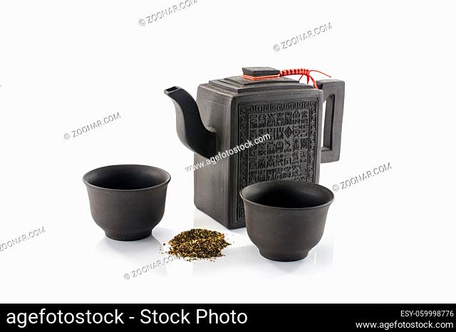 asian teapot and two cups with fresh dryed tea isolated on white