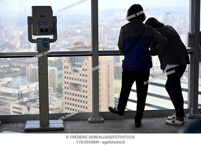 Two visitors to the Fukuoka Tower get a commanding view of the waterfront and city skyline, Japan, Asia
