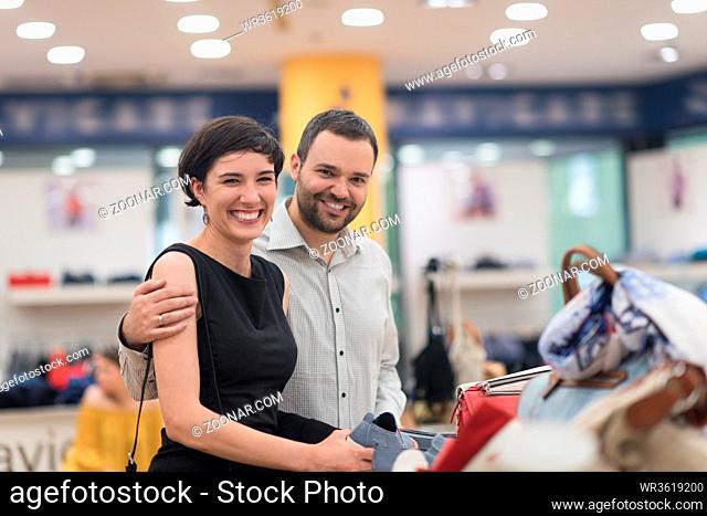 A young attractive couple changes the look with new shoes At Shoe Store