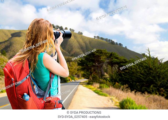 woman with backpack and camera at big sur coast