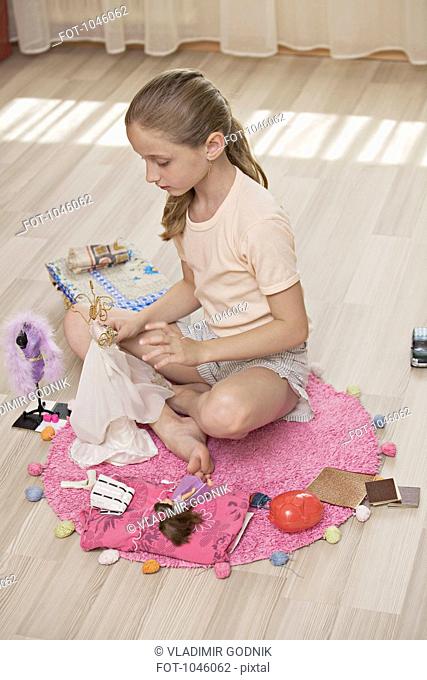 A girl playing with dolls
