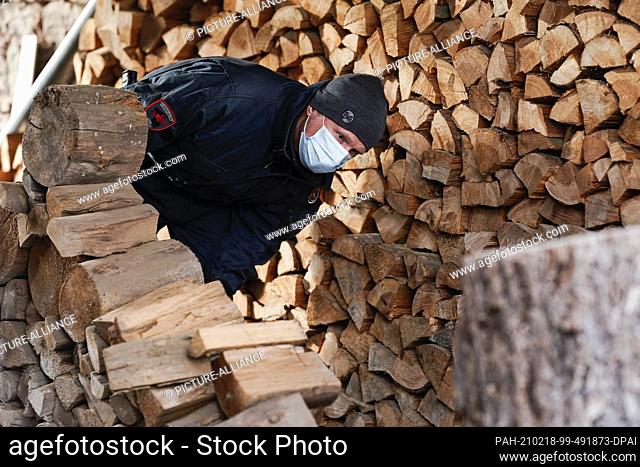 18 February 2021, Rhineland-Palatinate, Fischbach: An employee of the Explosive Ordnance Disposal Service examines a pile of wood
